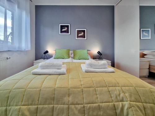 - une chambre avec un grand lit jaune et des oreillers verts dans l'établissement CLASSY APARTMENTS - AQUAPARK Reda, à Reda
