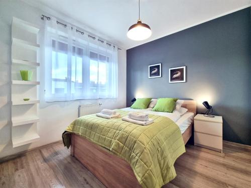a bedroom with a bed with green sheets and a window at CLASSY APARTMENTS - AQUAPARK Reda in Reda