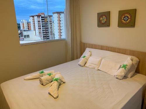 a bedroom with a bed with towels and a window at Apartamento tipo Flat para temporada em Caldas Novas com cozinha in Caldas Novas