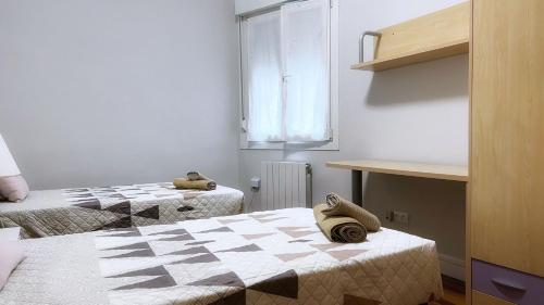 Cette petite chambre comprend 2 lits et une fenêtre. dans l'établissement Centrico y amplio apartamento con wifi, à Bilbao