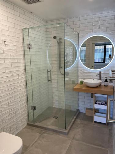 W łazience znajduje się szklana kabina prysznicowa i umywalka. w obiekcie 66 Express luxury apartment in New Market Our apartments has Self-checkin System w Auckland