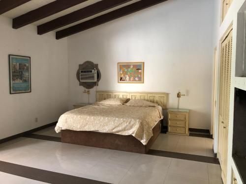 a bedroom with a bed and a tv on the wall at Casa La Bonita in Cuernavaca