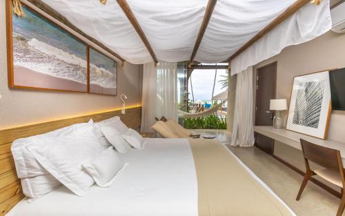 een slaapkamer met een groot wit bed en een bureau bij Flor de Lis Exclusive Hotel in Maceió