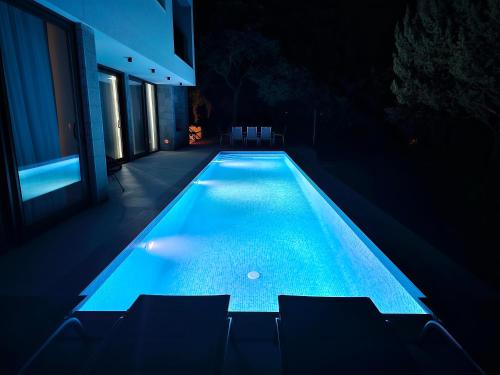 uma piscina no meio de uma casa à noite em Villa Lapidea em Sinj