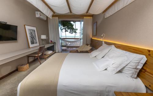 Schlafzimmer mit einem großen weißen Bett und einem Schreibtisch in der Unterkunft Flor de Lis Exclusive Hotel in Maceió