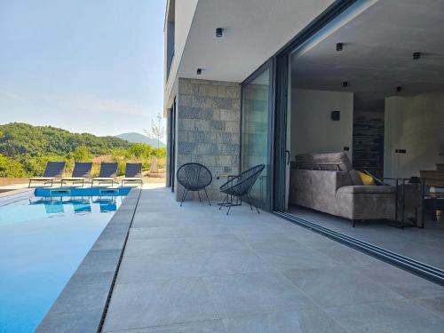 uma vista exterior de uma casa com piscina em Villa Lapidea em Sinj