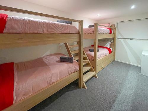 a room with three bunk beds in a room at Frostwood in Mount Buller