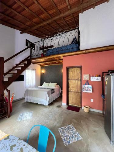 レンソイスにあるChalés Calimaのベッドと階段付きの広い客室です。