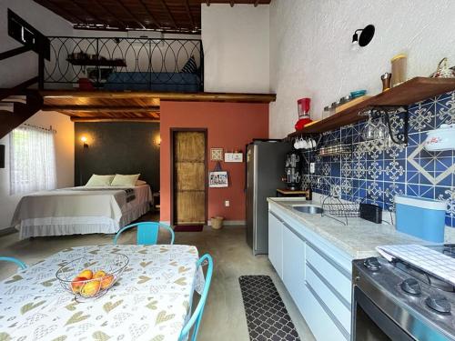 eine Küche mit einem Tisch und einem Bett in einem Zimmer in der Unterkunft Chalés Calima in Lençóis