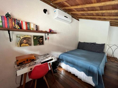 a bedroom with a bed and a desk with a keyboard at Chalés Calima in Lençóis