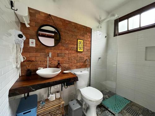 ein Badezimmer mit einem Waschbecken, einem WC und einem Spiegel in der Unterkunft Chalés Calima in Lençóis