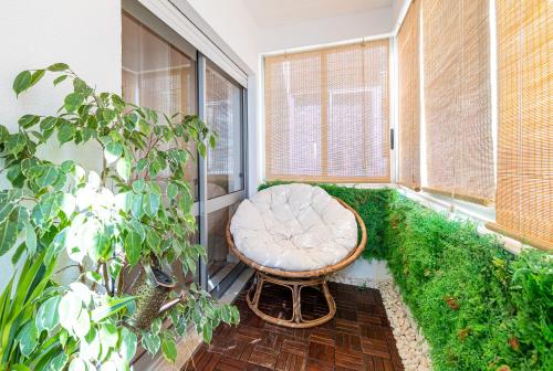 a small balcony with a chair and plants at COZY BOHO HOUSE, Elegance & Comfort in Faro Center in Faro