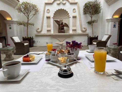a table with food and orange juice on it at Palacio Borghese Hotel Boutique - Adults Only in Oaxaca City