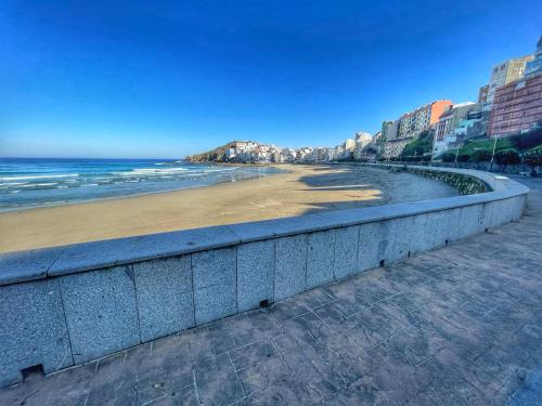 una playa con una pared de retención junto al océano en Malpica diseño, en Malpica de Bergantiños