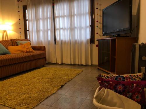 sala de estar con sofá y TV de pantalla plana en Amplia casa para 6 huéspedes en Mendoza en Godoy Cruz