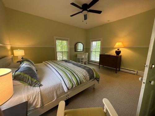 a bedroom with a bed and a ceiling fan at The Belvedere B&B in Charlevoix
