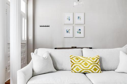 ein weißes Sofa mit einem gelben und weißen Kissen in der Unterkunft Luxury home in the historic Fan District in Richmond