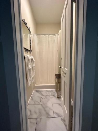 uma casa de banho com chuveiro e piso em azulejo em The Belvedere B&B em Charlevoix