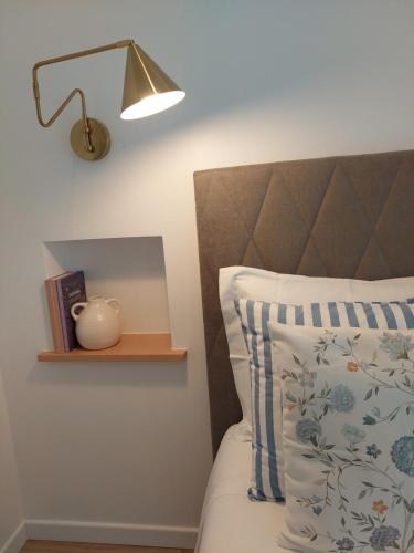 a bedroom with a bed with a lamp and a pillow at Lagoa azul guest house II in Vila Nova de Milfontes