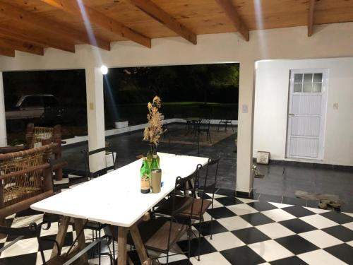 einen weißen Tisch und Stühle auf einem karierten Boden in der Unterkunft LA MAMA in Mercedes