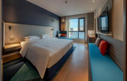 a bedroom with a large bed and a large window at Holiday Inn Express Kunming West, an IHG Hotel in Kunming