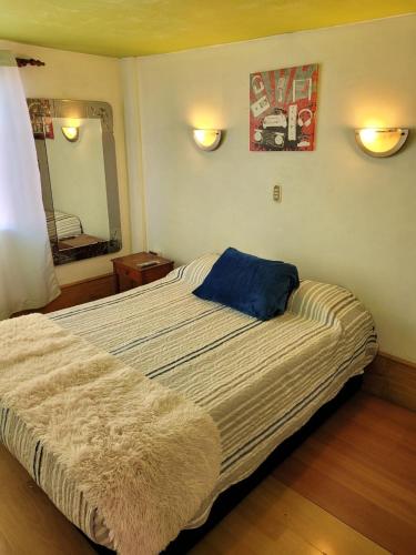 Un dormitorio con una cama grande con una almohada azul. en Económicas y Cómodas Habitaciones Privadas cerca de Playa en Arica