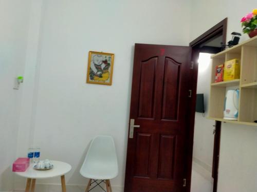 Zimmer mit einer Tür, einem Tisch und einem Stuhl in der Unterkunft Traveler’s choice home in Vietnam 1 in Củ Chi