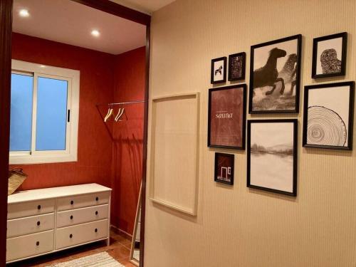 a bedroom with pictures on the wall and a dresser at Apartamento Casco-Antiguo Tarraco in Tarragona