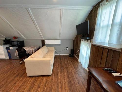 ein Wohnzimmer mit einem Sofa und einem Tisch in der Unterkunft Eden Farm: Private Studio Minutes from Salisbury in Eden