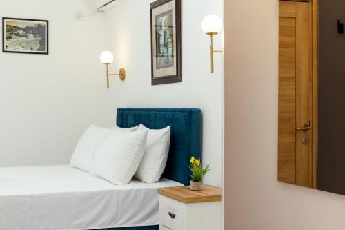 a bedroom with a bed with a blue headboard and a mirror at Barba Apartments in Ulcinj