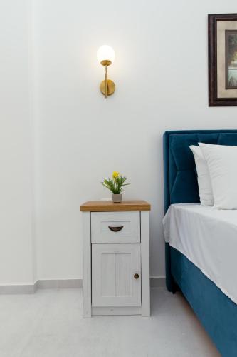 a white nightstand with a plant on it next to a bed at Barba Apartments in Ulcinj