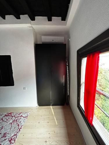a hallway with a black door and a window at House of Sokolovi Kratovo in Kratovo
