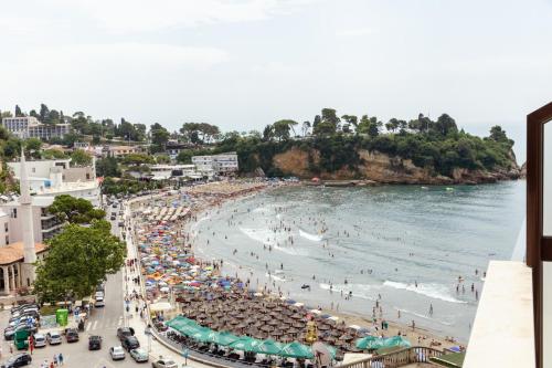 a beach with a crowd of people and the ocean at Barba Apartments in Ulcinj