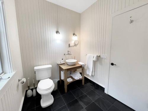 ein Badezimmer mit einem weißen WC und einem Waschbecken in der Unterkunft Cottage Retreat - Historic Cottage Home w Home Gym 