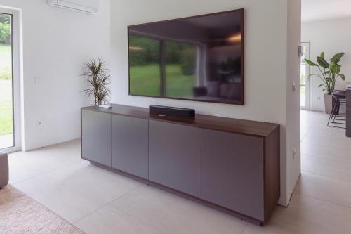 a living room with a tv on a wall at Villa Olivetum in Sečovlje