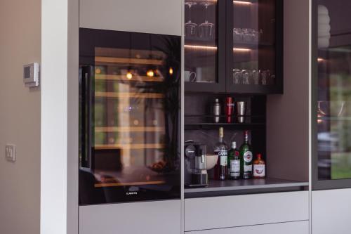 a kitchen with glass doors and bottles of alcohol at Villa Olivetum in Sečovlje