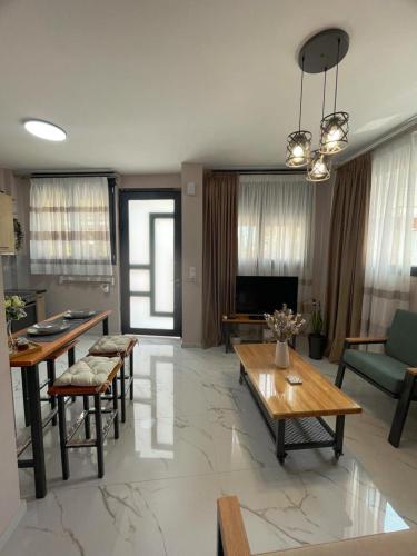 a living room with tables and chairs and a television at Anastasia's Luxury House in Kavala
