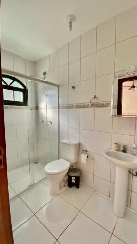 y baño con aseo y lavamanos. en CASA VERDE en Ubatuba