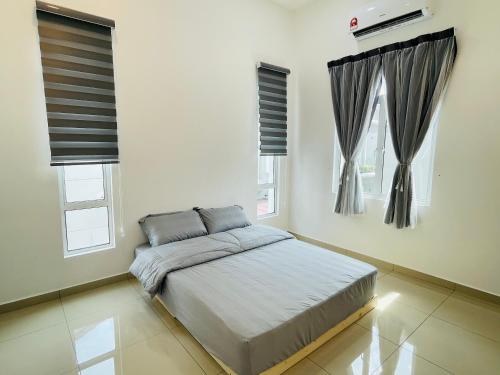 Un dormitorio con una cama y dos ventanas. en Casa Forest Homestay, en Keluang