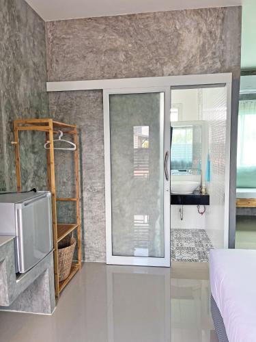 a bedroom with a bed and a sliding glass door at บ้านพักบุหงา199 แฟมิลี่ อ สรรพยา ชัยนาท in Ban Oi Noi (2)