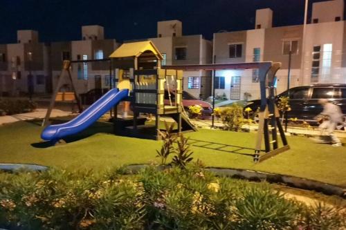 a playground with a slide in a yard at night at Hermosa casa en condominio in Cancún