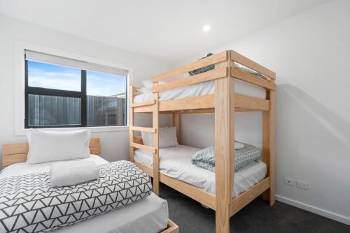 a bedroom with two bunk beds and a window at CatchN'Relax Taupo in Taupo