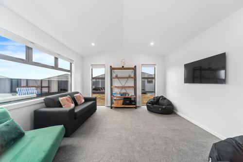 a living room with a couch and a tv at CatchN'Relax Taupo in Taupo