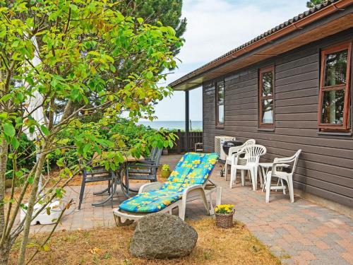 a patio with chairs and a bench and a table at 4 person holiday home in Glesborg in Glesborg