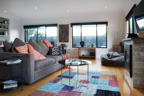 a living room with a couch and a fireplace at Absolute in Daylesford