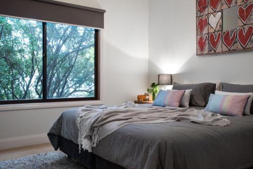 a bedroom with a large bed with a large window at Absolute in Daylesford