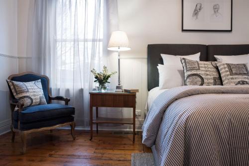 a bedroom with a bed and a blue chair and a table at Albion in Daylesford