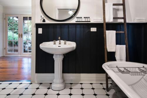 a bathroom with a sink and a tub and a mirror at Albion in Daylesford