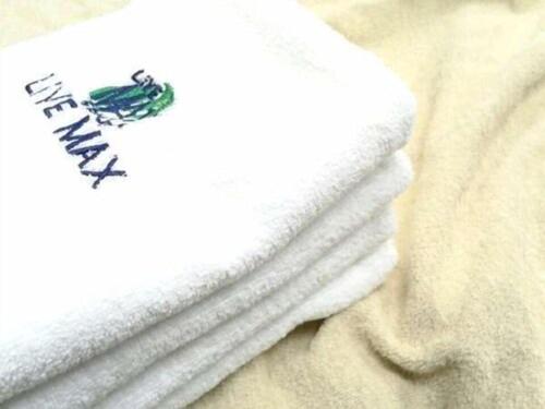 una pila de toallas blancas con una rana en ellas en HOTEL LiVEMAX BUDGET Gunma Numata, en Numata