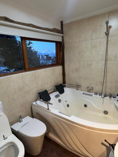 a bathroom with a bath tub and a toilet and a toilet at Morada del Leñador in Ushuaia